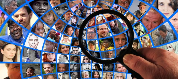 A diverse group of faces and a magnifying glass