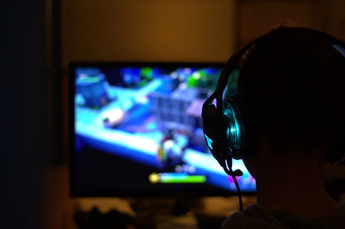 A boy playing games and wearing a headset