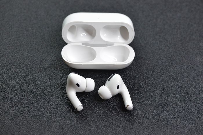 A pair of Apple AirPods Pro next to their case